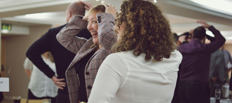 Lady standing with hands on her head playing a game