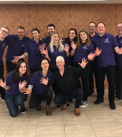 The Indigo Swan team standing in front of a brick wall