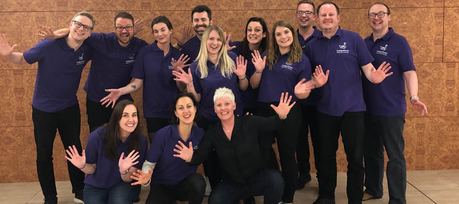 The Indigo Swan team standing in front of a brick wall 