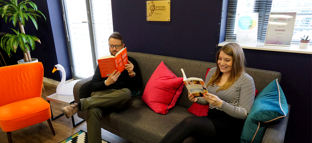 Hayley and James sitting on the sofa reading books