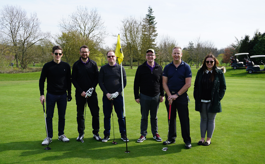 Group of people standing near the 18th hole on golf course