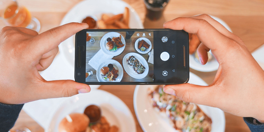 Person taking a photo of food on phone