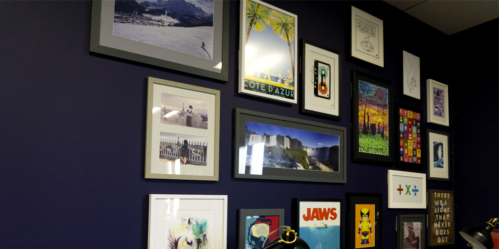 Picture frames with images hanging on purple wall