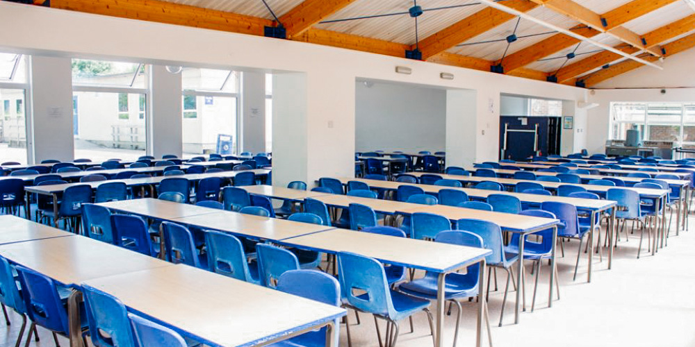 Tables and chairs lined up in a classroom 